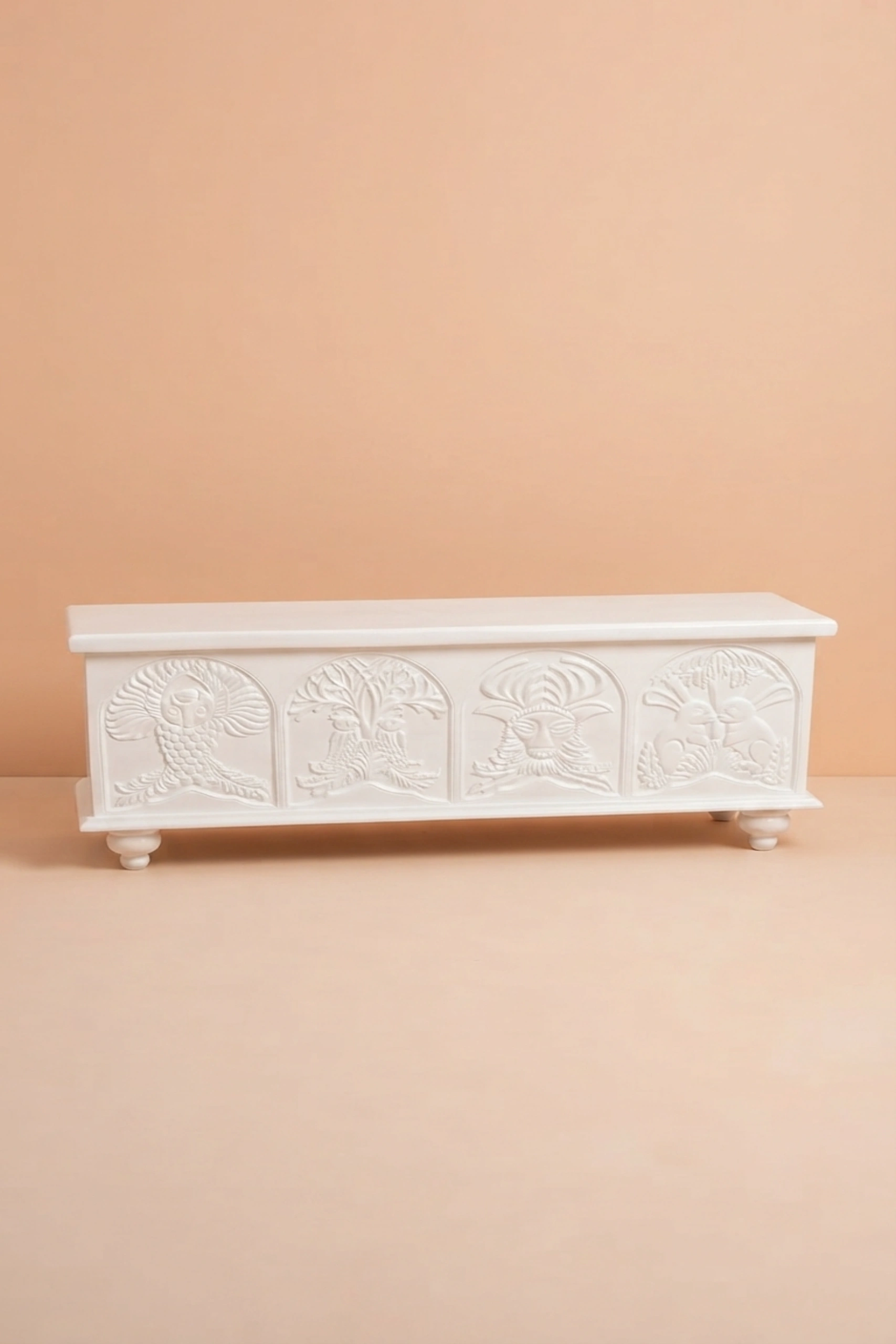 Handcarved_Menagerie_Trunk_White_image_02_angled_view_luxury_handcarved_storage_trunk_chest_white_decorative_bedroom_living_room_artisan_premium_furniture.webp